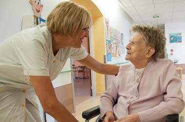 infirmière avec une patiente senior en chaise roulante